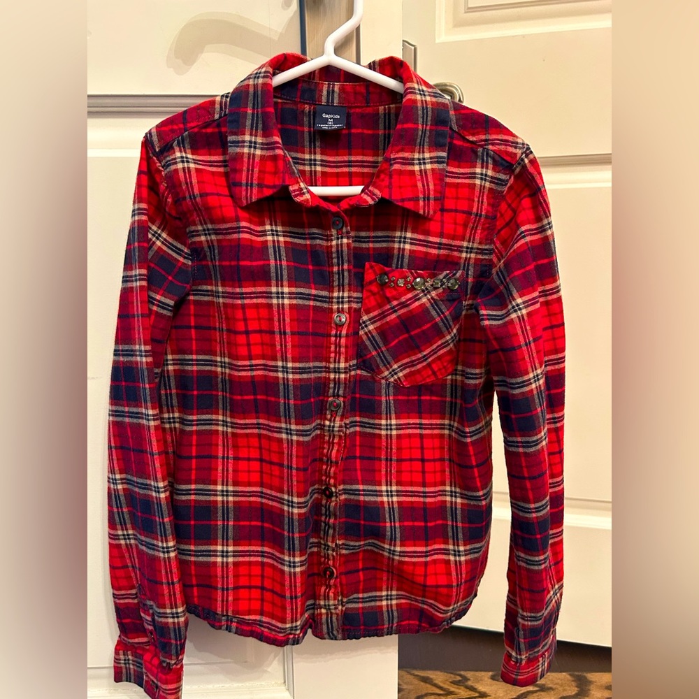 Red plaid shirt with jewels on front pocket.